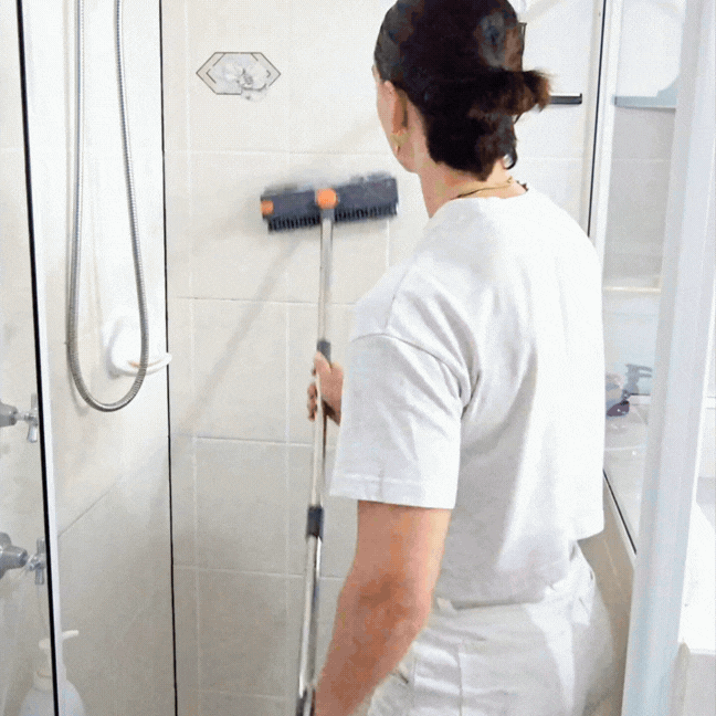 Nettoyage des joints de carrelage du mur de douche avec le manche long