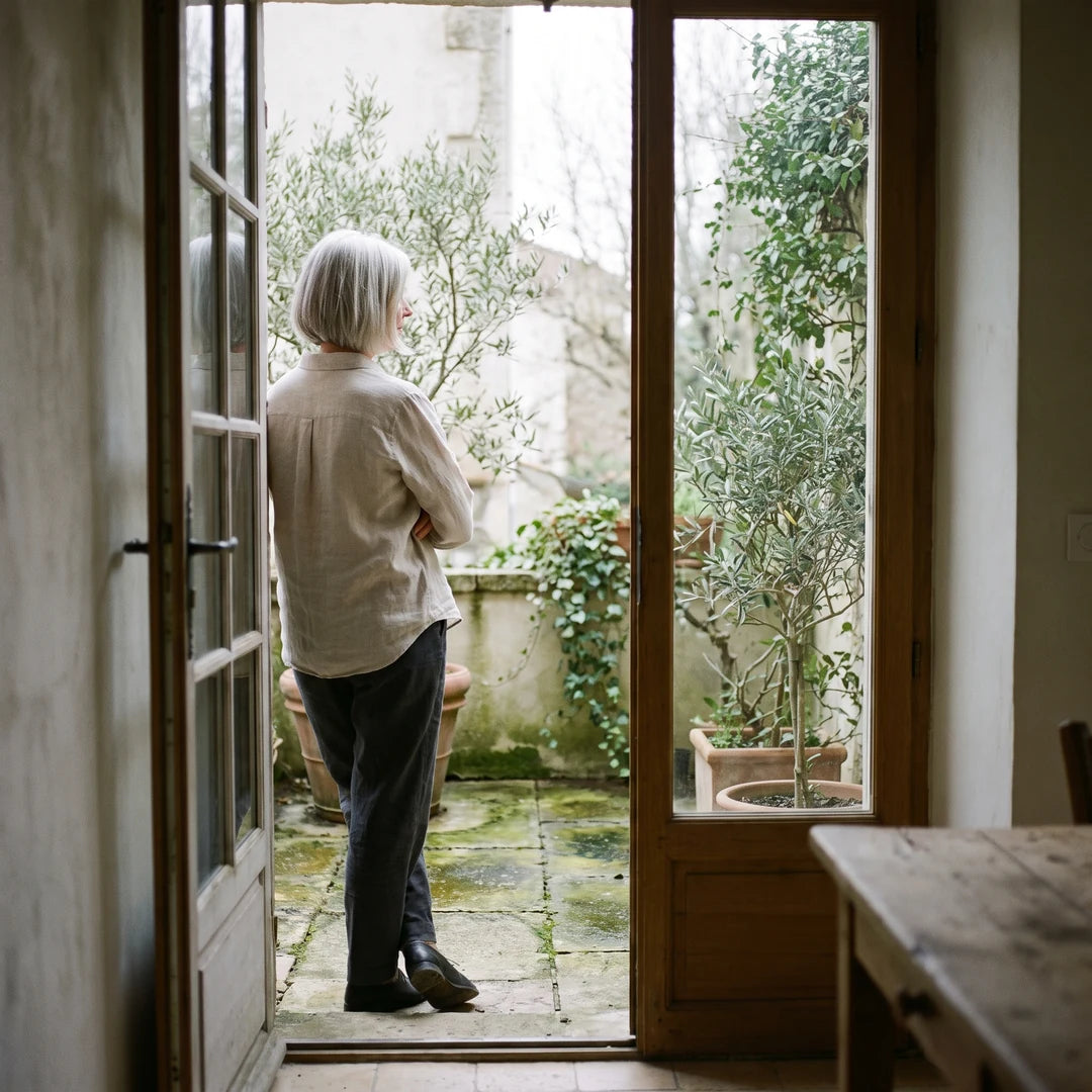 Terrasse en pierre verdie par les mousses, regardée depuis l'intérieur de la maison